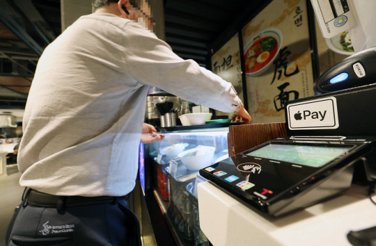 애플의 비접촉식 간편결제 서비스인 '애플페이' 서비스 개시를 하루 앞둔 20일 서울 시내의 한 음식점 계산대에 애플페이 스티커가 붙어있다.애플과 현대카드는 21일 애플페이의 한국 서비스 개시를 목표로 출시 마무리 작업을 진행 중이다.         연합뉴스